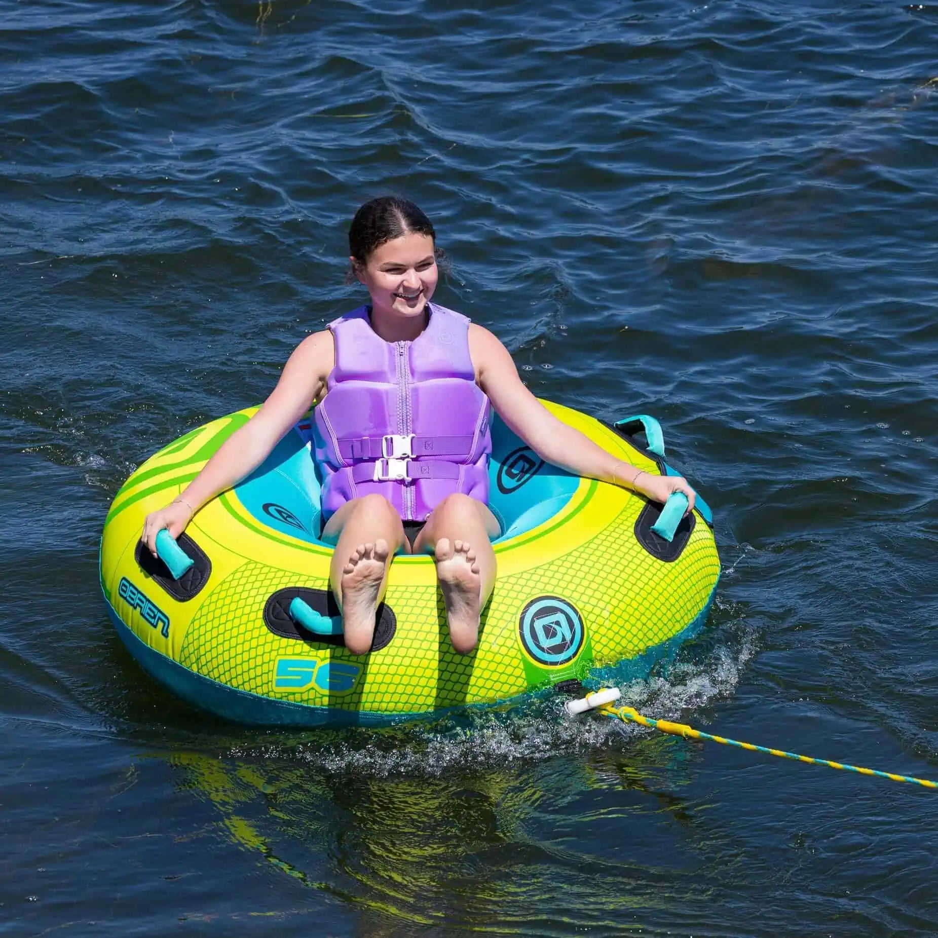 a woman is sitting on the O'Brien Le Tube Deluxe - Towable Boat Tube in the water