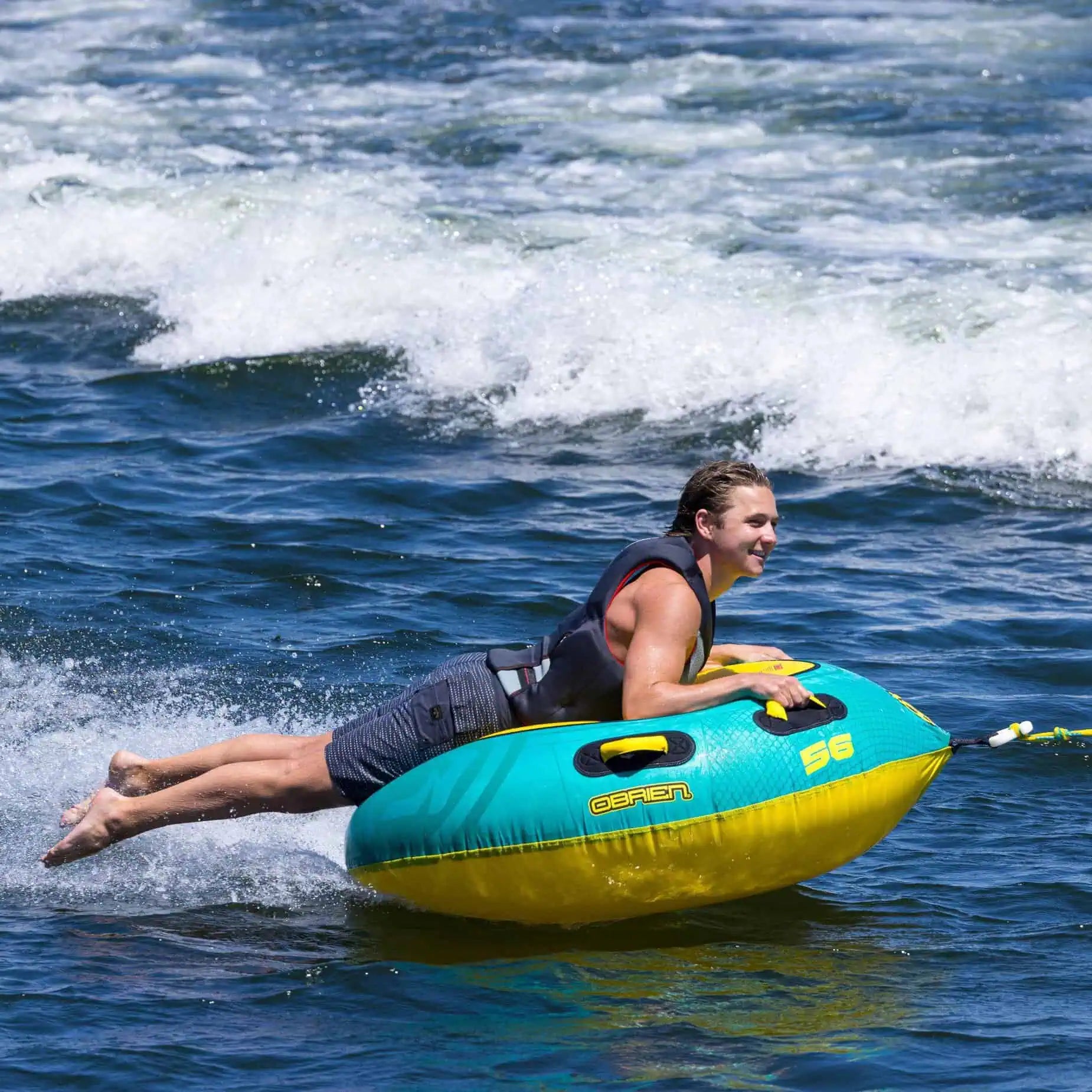 young man riding on the O'Brien Le Tube Towable Boat Tube on the water