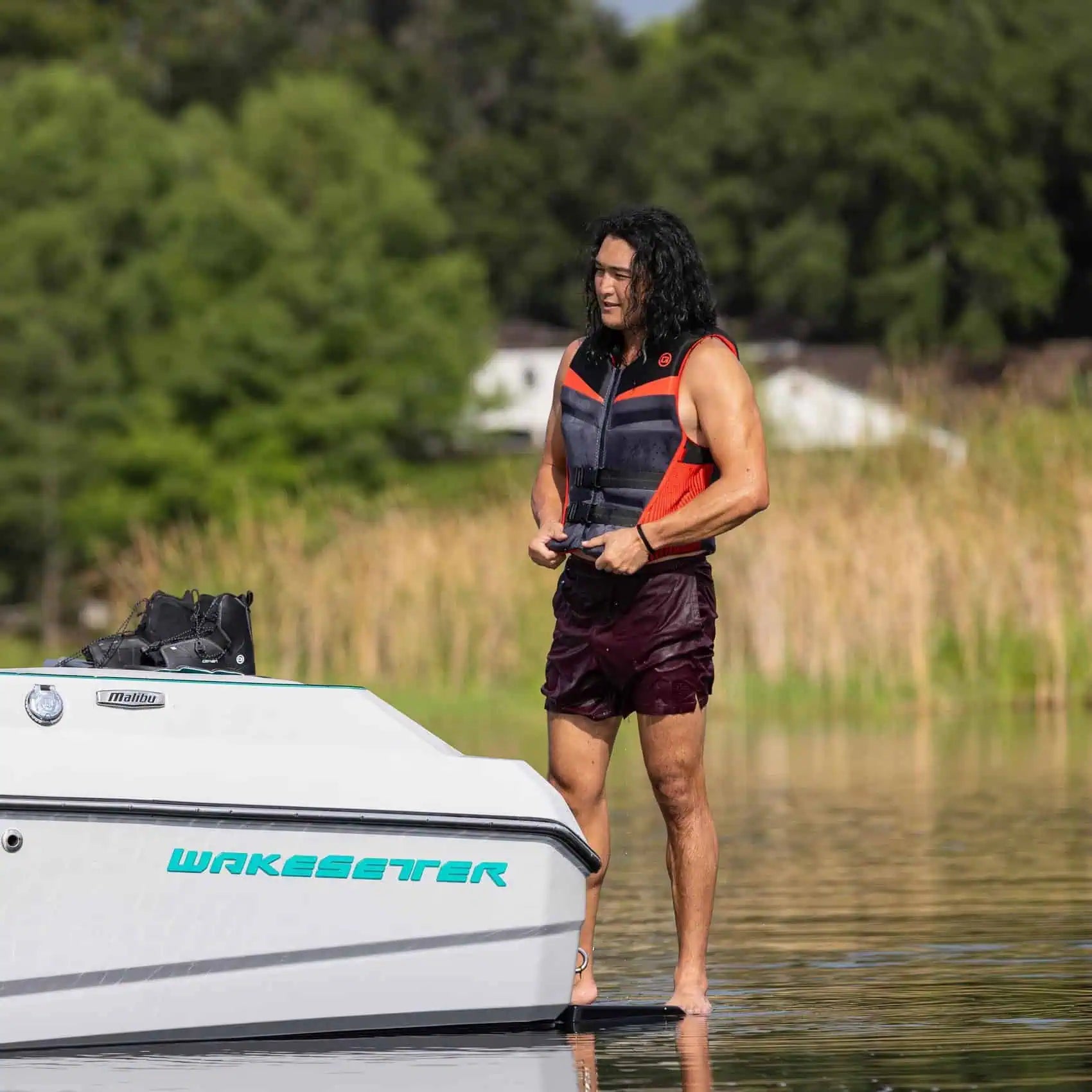 Man standing on a boat with O'Brien Men's Flex V-Back Life Jacket