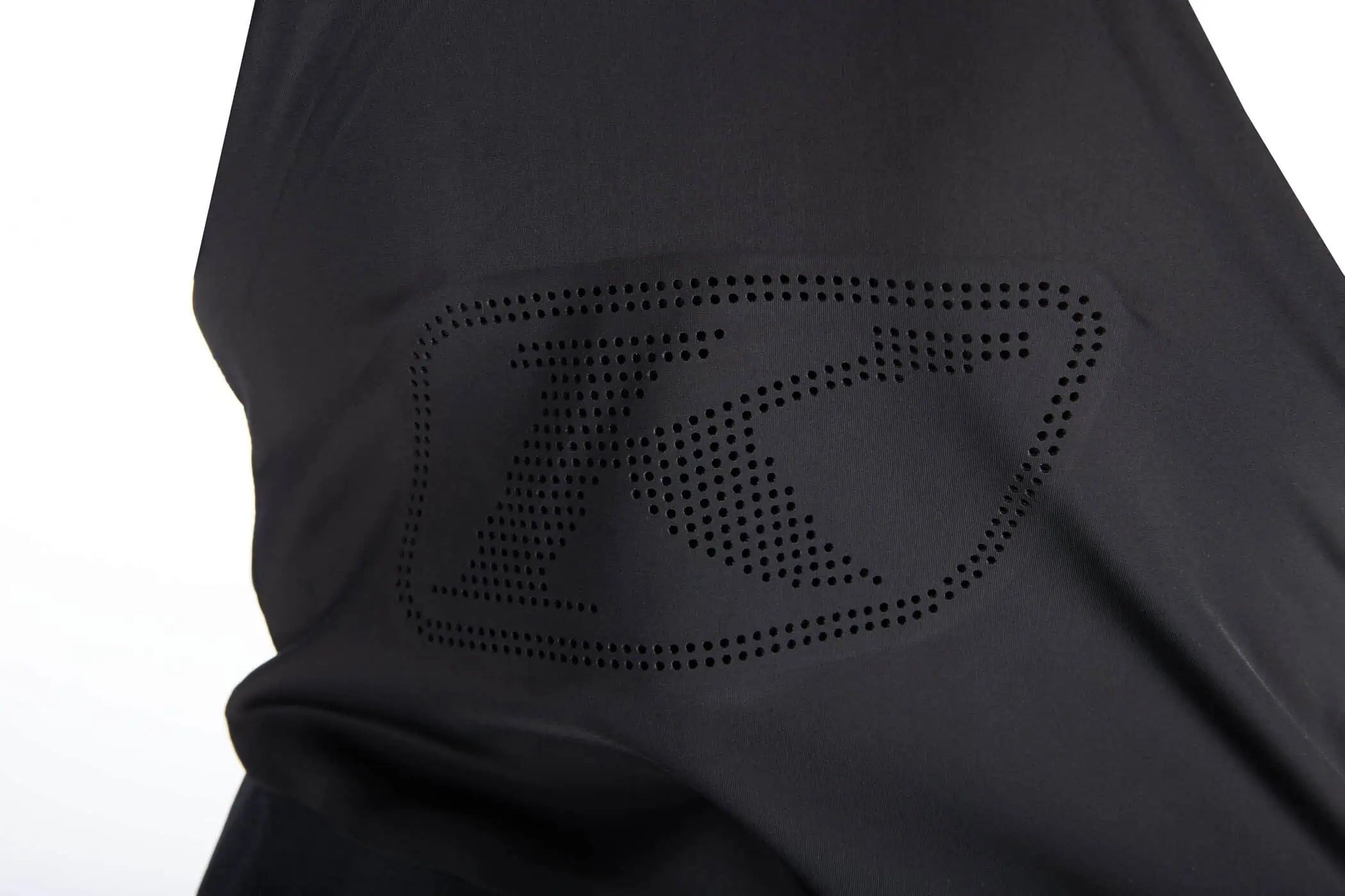 Close-up of a Klim Togwotee Bibfeaturing a tonal, dotted 'K' logo on the chest, set against a plain white background.