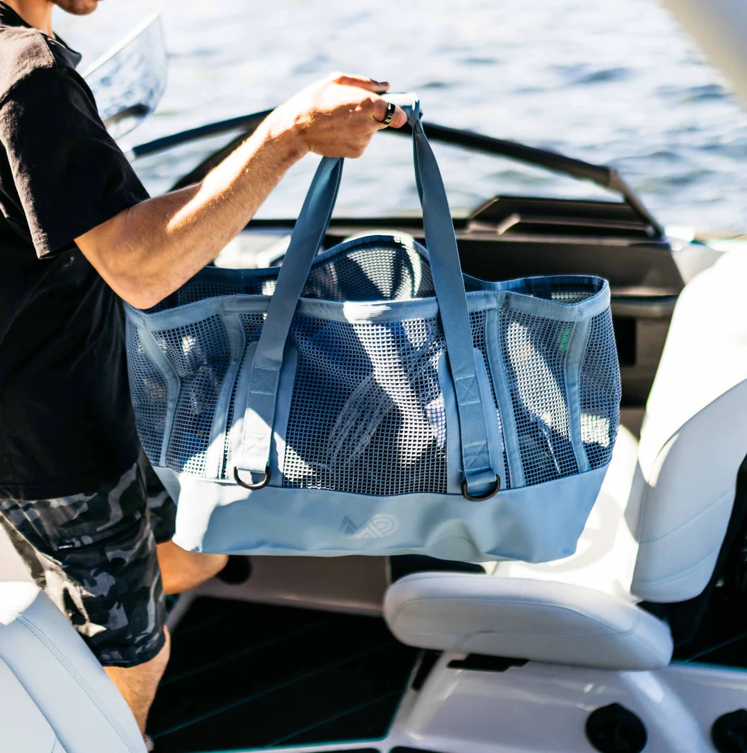 Person holding a steel blue Mission Cassi Gear Tote - Heavy-Duty Boat and Beach Bag on a boat