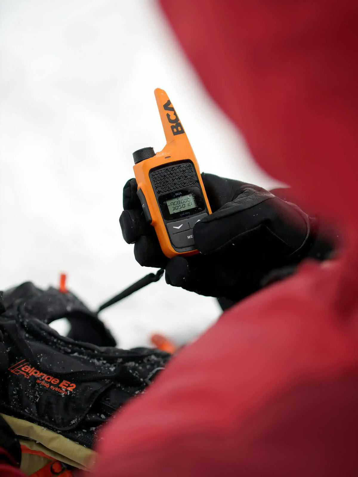 BCA BC Link Mini Radio held by a gloved hand with a blurred background