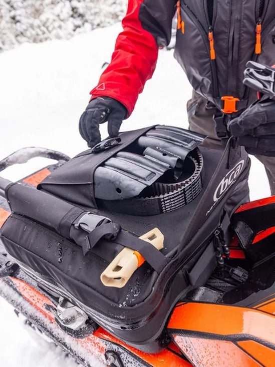 Person adjusting the BCA Mtn Pro Tunnel Bag in a snowy environment
