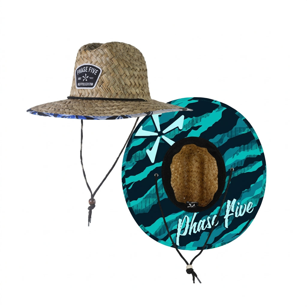 A full-brimmed straw hat with a woven patch on the front crown and an adjustable black chin strap. Features a printed lining under the brim.