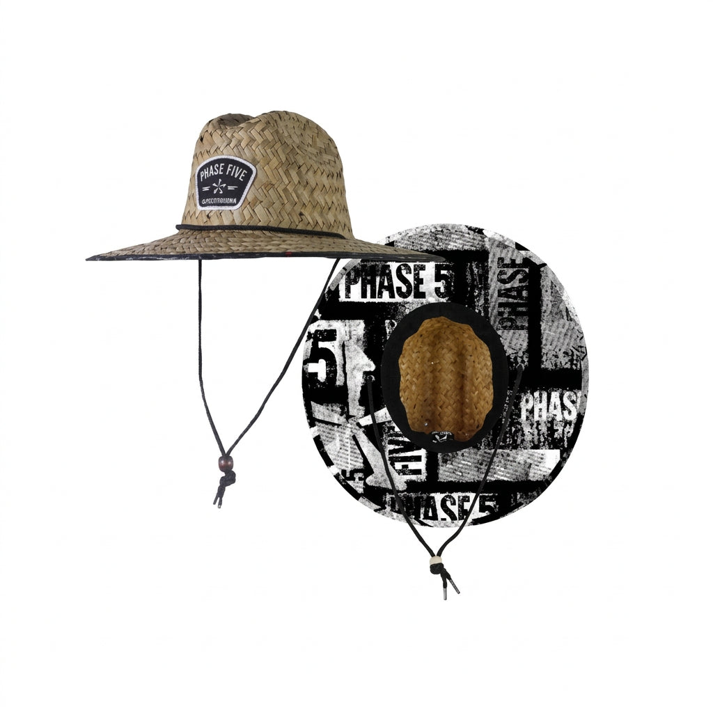 A full-brimmed straw hat with a woven patch on the front crown and an adjustable black chin strap. Features a printed lining under the brim.