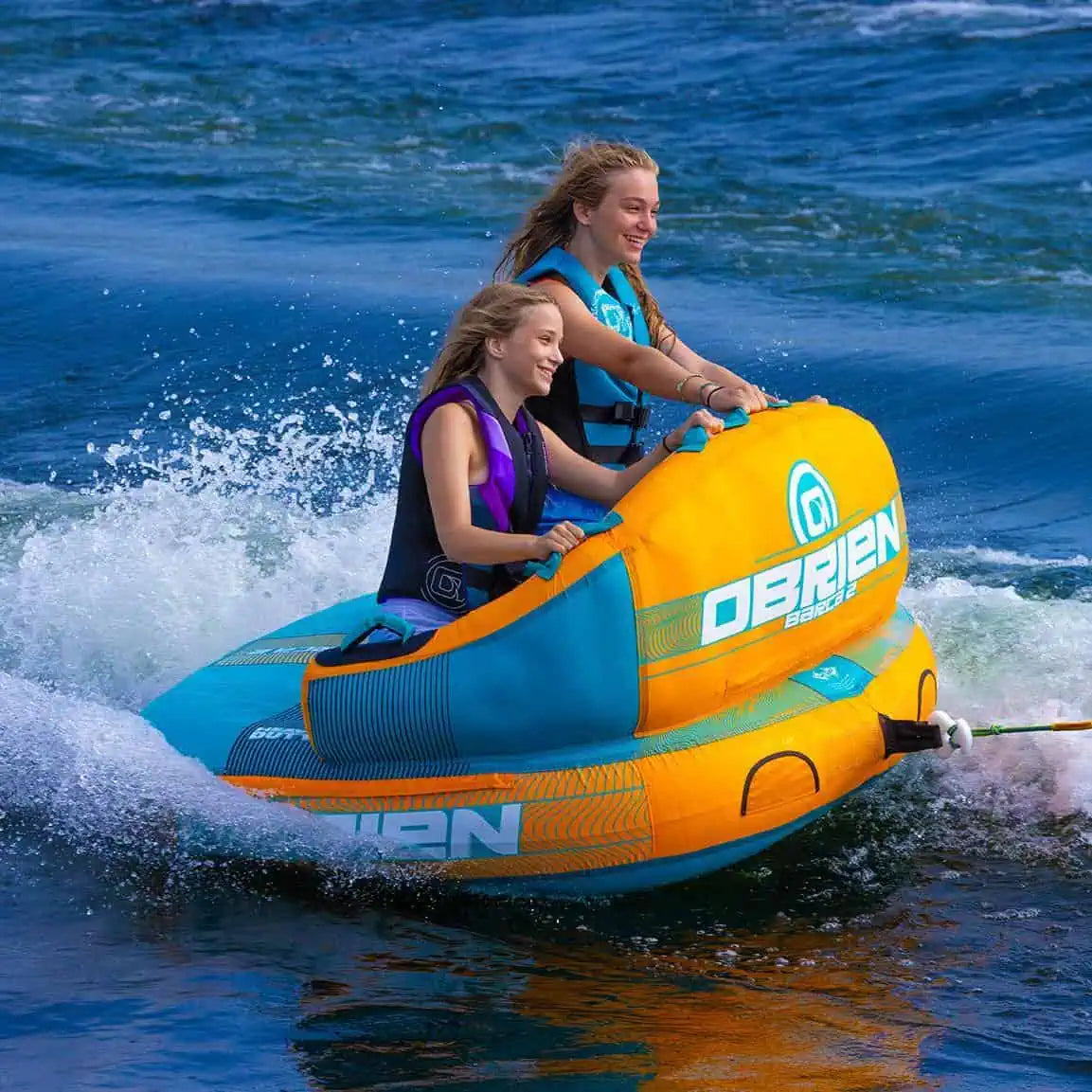 Two people on an O'Brien Barca - 2 Person Towable Boat Tube in the water