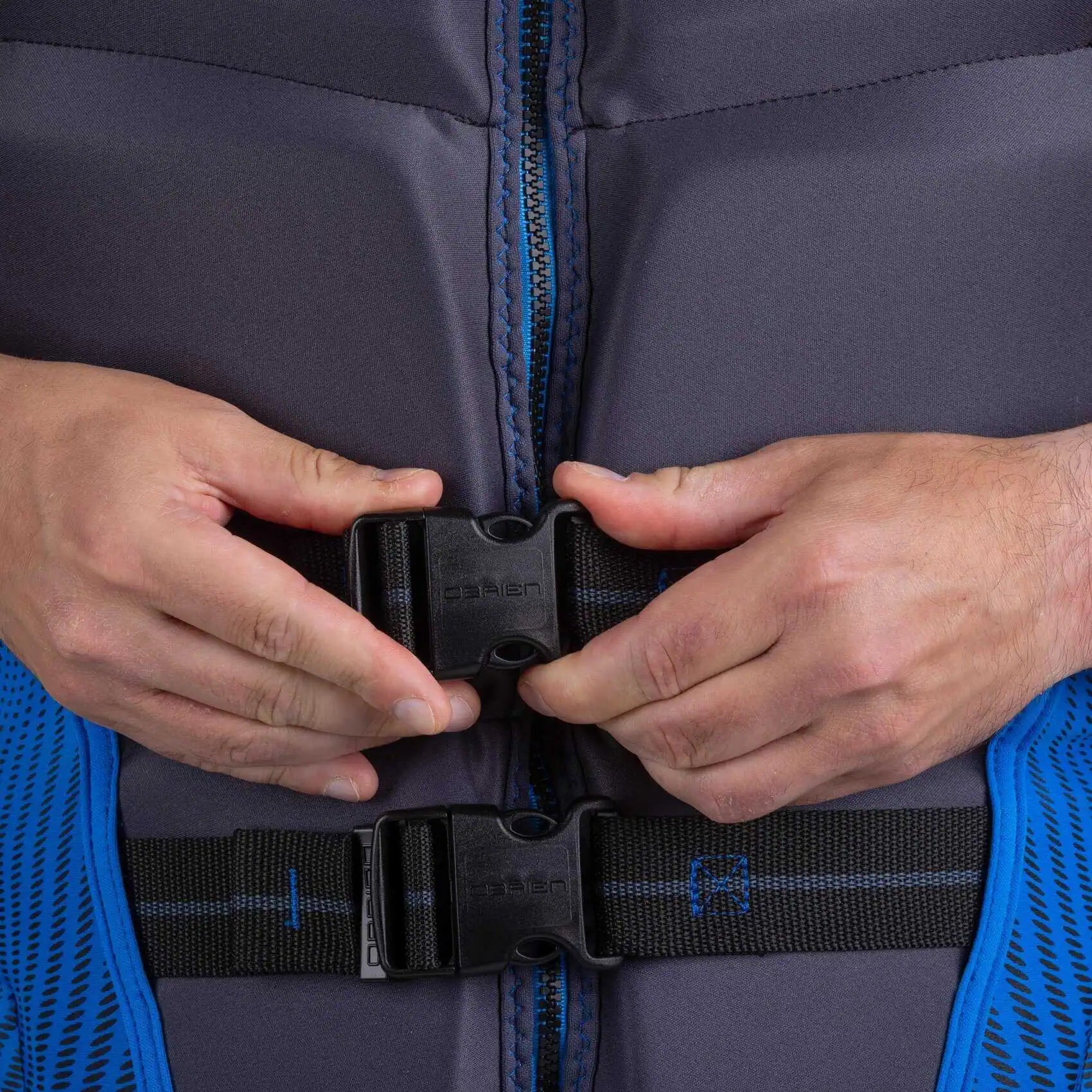 Close-up of hands adjusting a O'Brien Men's Flex V-Back Life Jacket