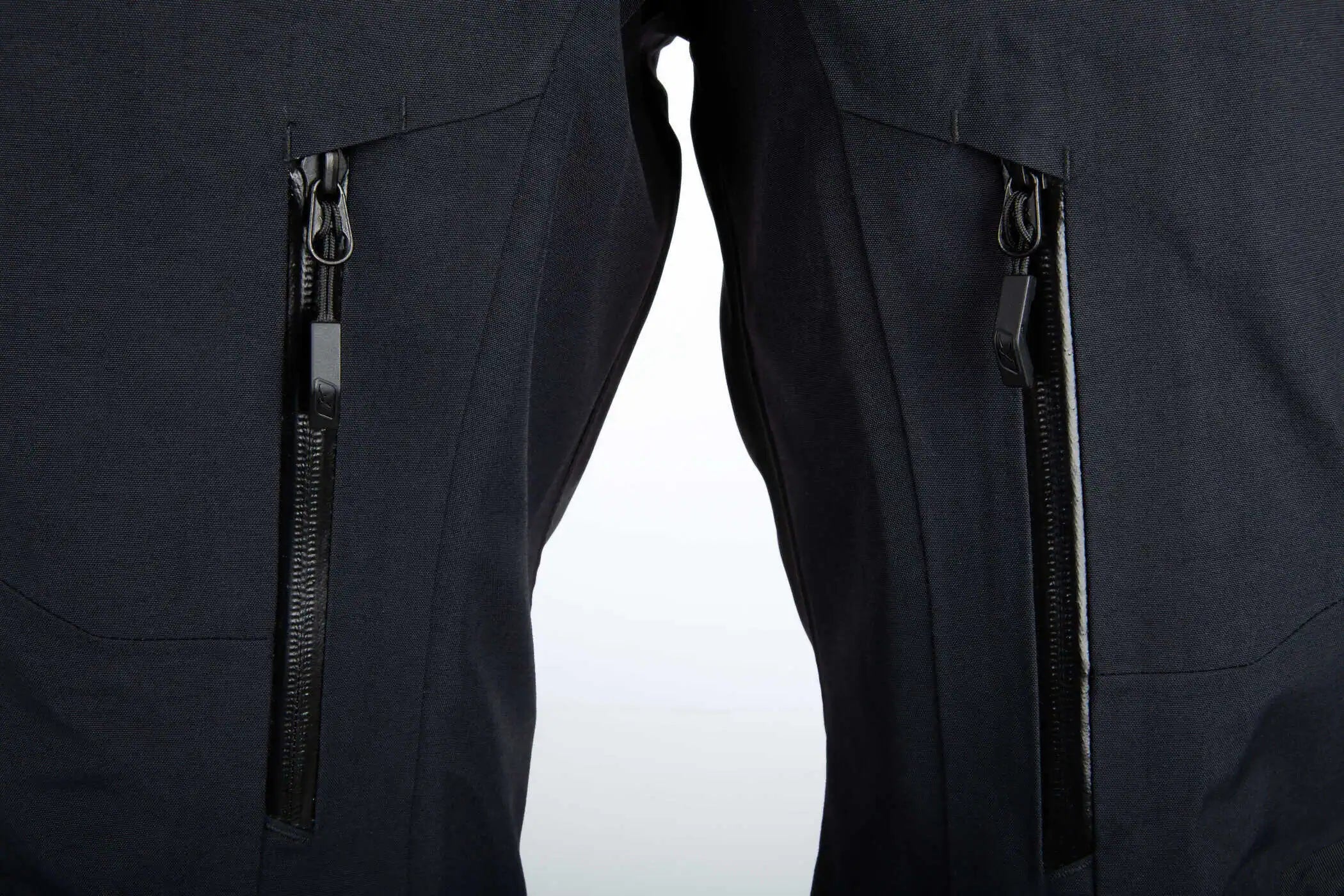 Close-up of Klim Togwotee Bib showing two vertical zippered pockets on the thighs.