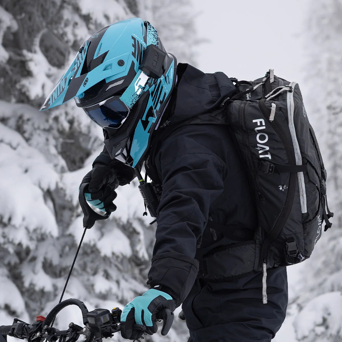 a person wearing the 509 Atmosphere Snowmobile Helmet - Glacier Blue, starting a machine