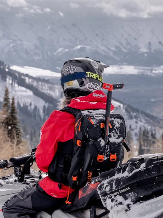 a person wearing the BCA Float E2 MtnPro Vest Avalanche Airbag on a snowmobile