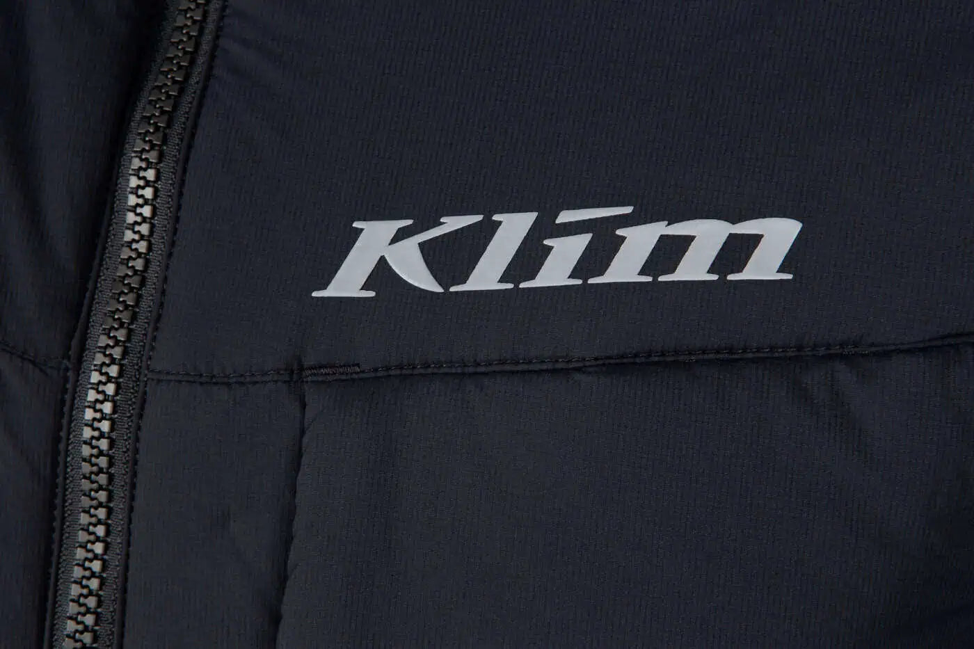 Close-up of a black Klim Men's Override Vest with 'Klim' logo on a dark background