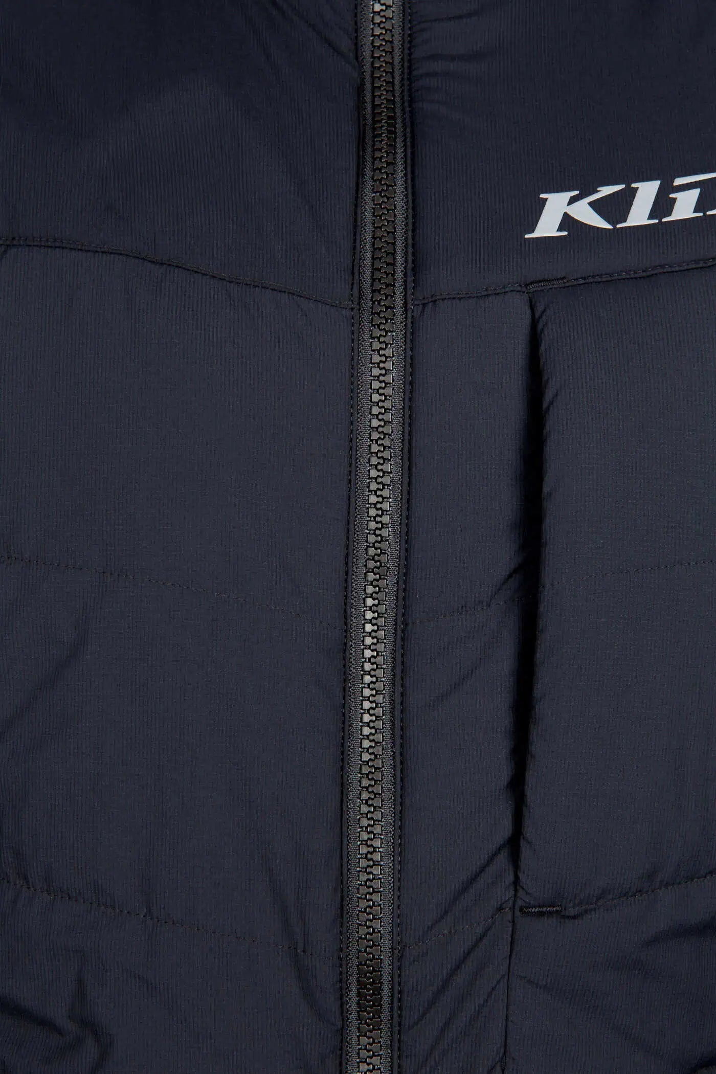 Close-up of a black Klim Men's Override Vest with a zipper, featuring the Klim logo.
