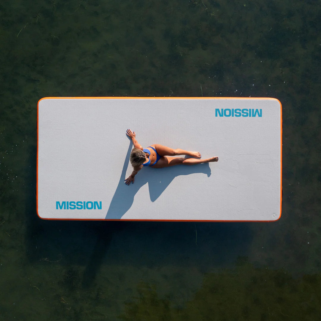 a person is lying on the Mission REEF MAT -  Inflatable Water Mat