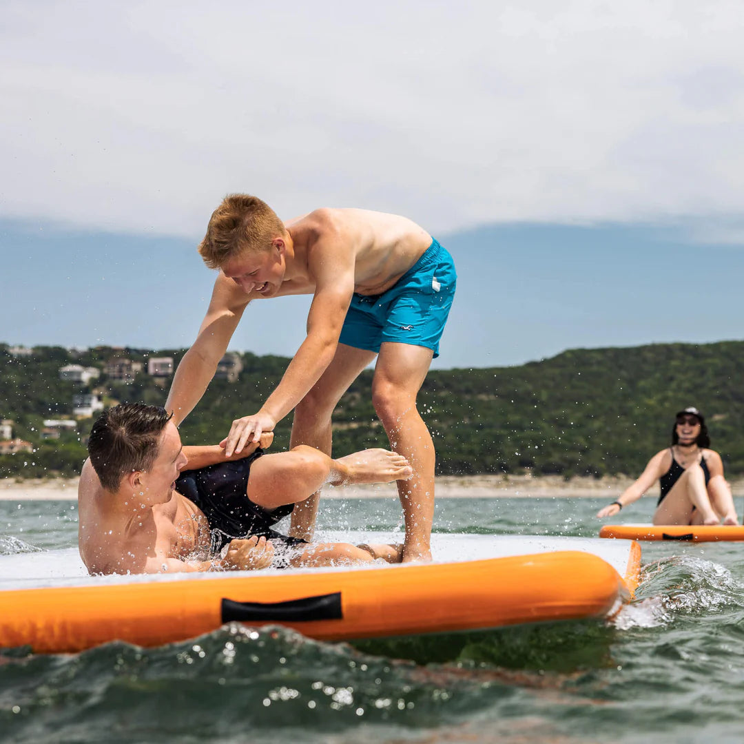 two friends are playing on the Mission REEF MAT -  Inflatable Water Mat