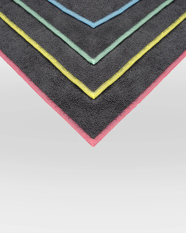 Set of colorful bath mats with gradient edges on a light gray background