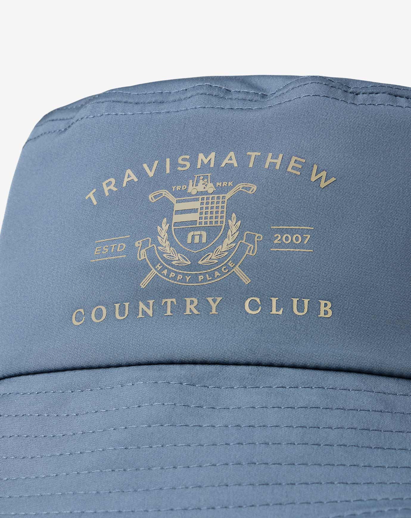 Blue cap with 'Travismathew Country Club' logo on a white background