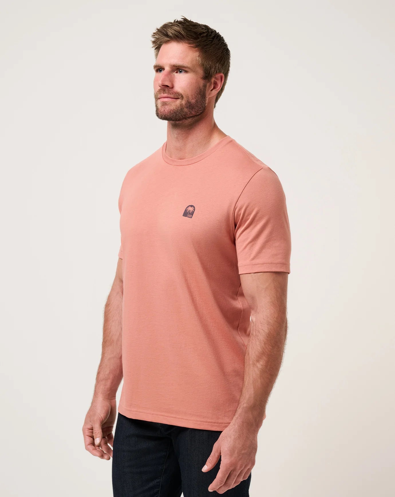 side view of TravisMathew Top Places Solid Tee in brick red